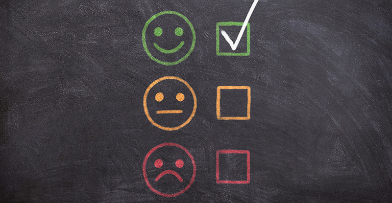 The F-Word: Exploring How to Use It A photo of a blackboard displaying smiley faces representing satisfaction levels—happy, neutral, and sad. The happy face is marked to indicate satisfaction.