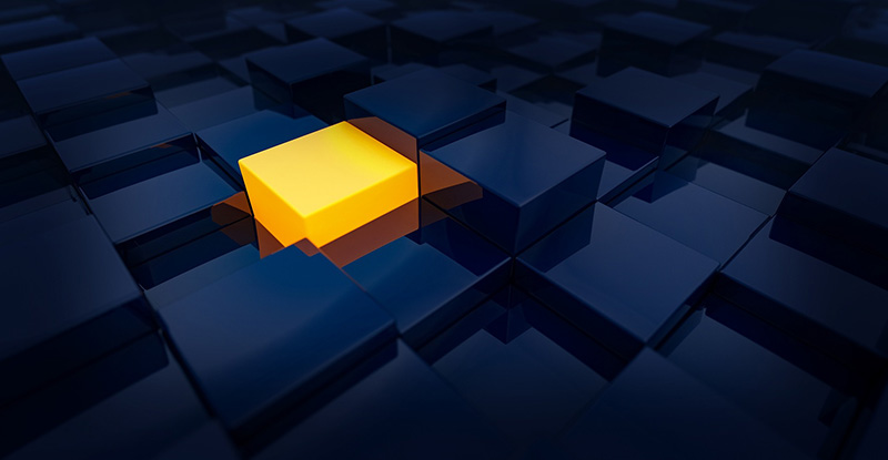 A photo of a dark room filled with blue cubes, with a fully lit yellow cube prominently glowing in the center.