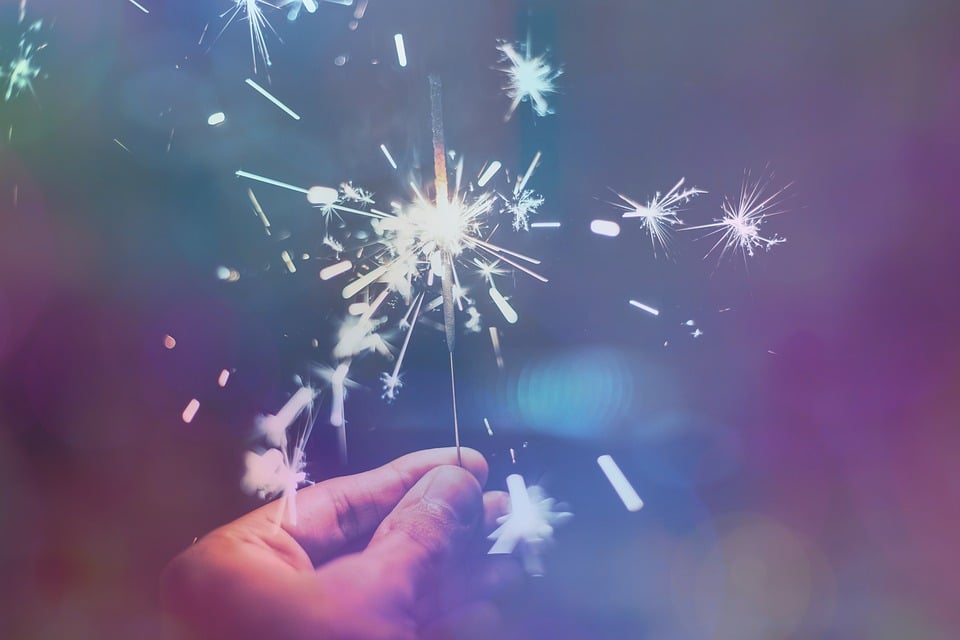 A photo of a person holding a sparkler creating a whimsical look.